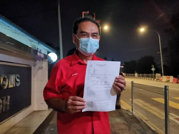 Muhammad Amin menunjukkan laporan polis yang dibuat di IPD Ipoh pada Jumaat berhubung fitnah yang mengaitkan dirinya dengan projek pembalakan di Batu Kurau.