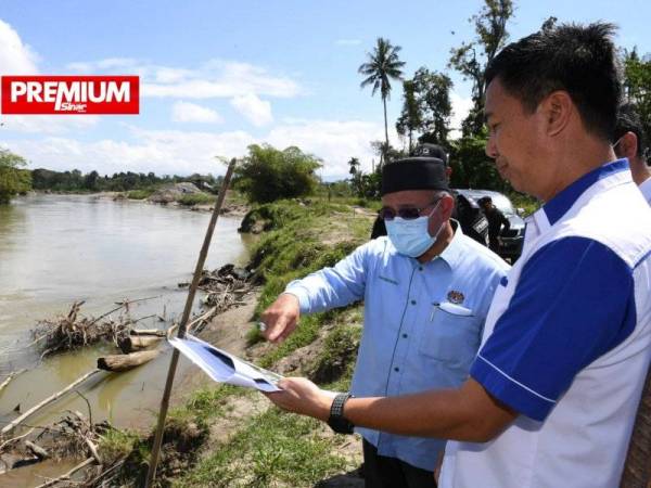 Tuan Ibrahim (kiri) diberi penerangan oleh Jurutera Jabatan Parit dan Saliran Kota Belud, Jaffri Bahan (kanan) mengenai kawasan tambatan banjir yang akan dibina di sungai Tempasuk ketika melakukan lawatan di kawasan banjir dan projek tebatan banjir pada Sabtu.