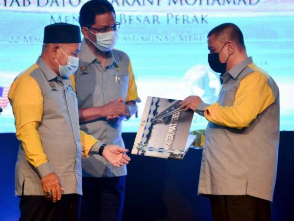 Tuan Ibrahim (kiri) dan Saarani (kanan) melihat buku Water Matters pada perasmian Sambutan Hari Air Sedunia Peringkat Negeri Perak di Ipoh pada Isnin. - FOTO: BERNAMA