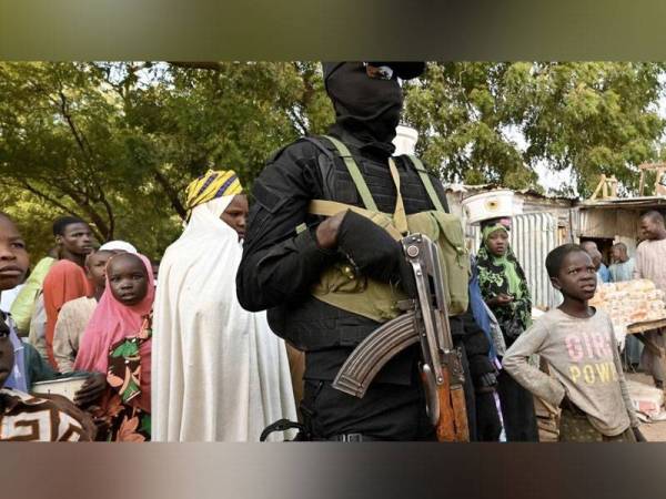 Gambar fail menunjukkan seorang pegawai polis mengawal pasar dekat sebuah lapangan terbang di Diffa, barat daya Niger. - Foto AFP