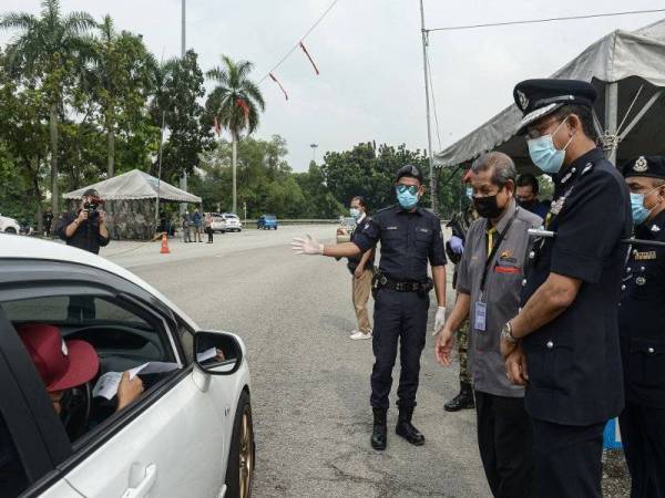 Mahmood (tiga dari kanan) membuat pemeriksaan ke atas pengguna jalan raya yang melalui SJR di Plaza Tol USJ pada Selasa. Turut sama Ketua Polis Daerah Subang Jaya, ACP Abd Khalid Othman (dua dari kanan). Foto Bernama