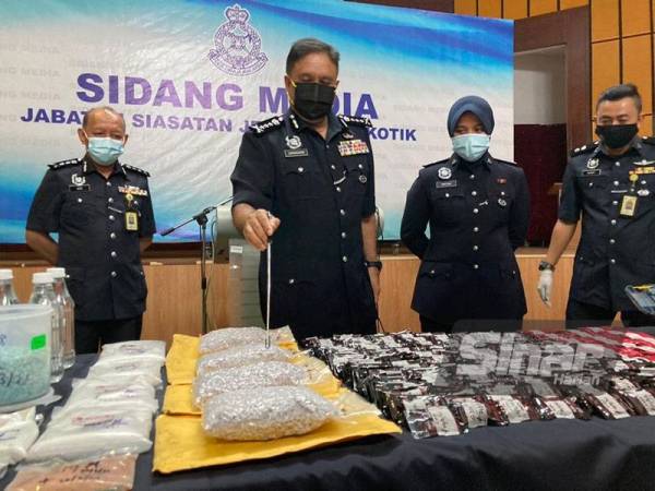 Sahabudin (tengah) menunjukkan dadah bernilai RM11.8 juta yang dirampas di rumah mewah yang dijadikan makmal memproses dadah.