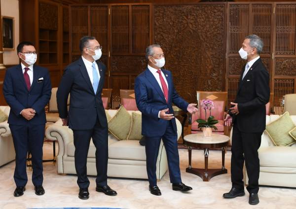 Perdana Menteri Tan Sri Muhyiddin Yassin (dua, kanan) beramah mesra dengan Menteri Luar Singapura, Dr Vivian Balakrishnan di pejabatnya pada Selasa. -Foto Bernama