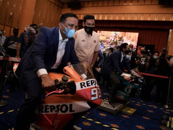 Reezal Merican mencuba aktiviti bermotosikal ketika melawat ruang pameran Retro Havoc E-motorshow pada Program MyFit@Motorsports di Menara Kementerian Belia dan Sukan (KBS) pada Rabu. -Foto: Bernama