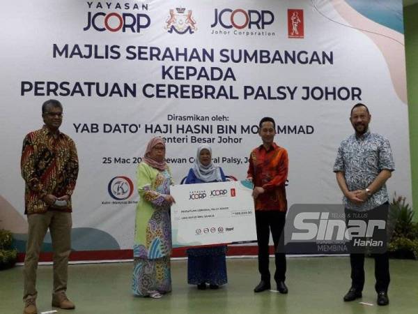 Zaiton (tengah) menyaksikan penyerah replika cek daripada Rozaini (kanan) kepada Fatimah selepas Majlis Serahan Sumbangan Kepada Persatuan Cerebral Palsy Johor di Dewan Cerebral Palsy Johor Bahru, pada Khamis.