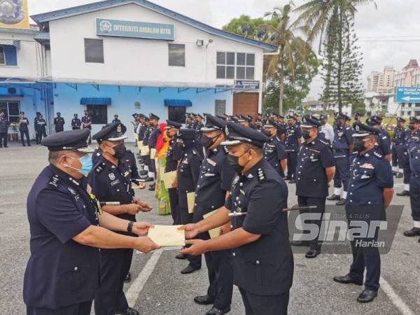 Roslee (kiri) menyerahkan sijil Anugerah Intergriti dan Tolak Rasuah kepada salah seorang pegawai polis sempena Majlis Perbarisan Peringatan Hari Polis ke-214 di perkarangan Ibu Pejabat Polis Kontinjen (IPK) Terengganu pada Khamis.