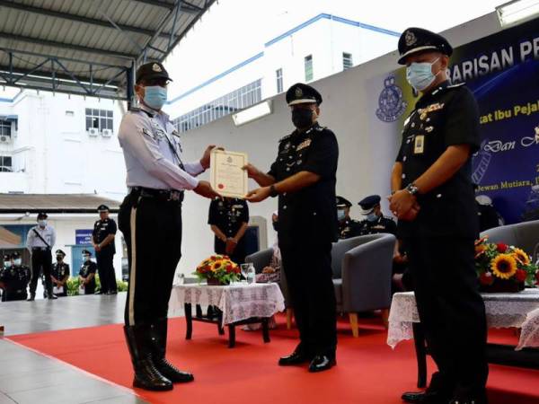 Shahabudin menyampaikan sijil penghargaan kepada salah seorang anggota pada Sambutan Peringatan Hari Polis Ke-214 di IPK pada Khamis.