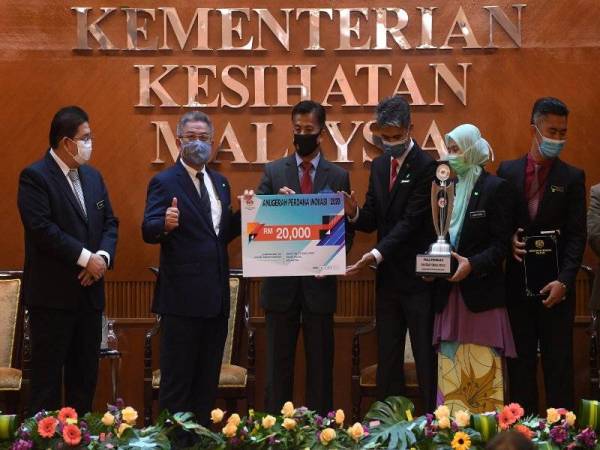 Dr Adham (dua dari kiri) menyampaikan Anugerah Perdana Inovasi 2020 kepada Pengarah Hospital Tengku Anis Pasir Puteh Kelantan, Dr Nor Hizulmy Noor Muhammad (tiga, kanan) hari ini. Foto Bernama