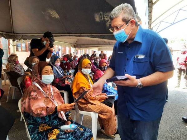 Saifuddin menyerahkan sumbangan kebajikan kepada golongan B40 pada Program erat Kasih Bersama Penduduk Balok Makmur, di Balok pada Sabtu.