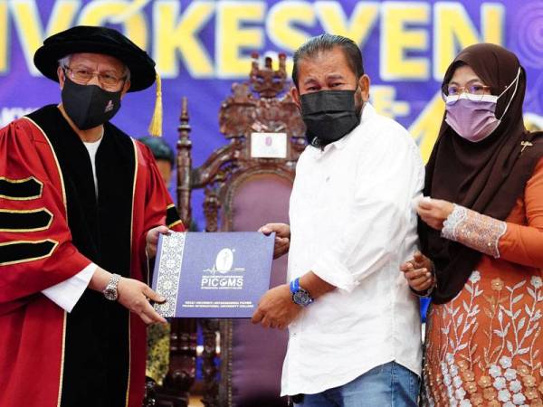 Shabri (tengah) sambil ditemani Zalina menerima diploma jurusan farmasi bagi pihak anaknya, Ayuni Shazwanie yang disampaikan oleh Zulkifli (kiri) pada Majlis Konvokesyen Kolej Universiti Antarabangsa PICOMS (PICOMS) kali ke-11 di Menara Bank Rakyat, Kuala Lumpur pada Sabtu.