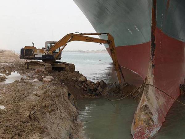 Usaha mengorek pasir dan lumpur pada bahagian lengkungan kapal MV Ever Given itu sedang giat dijalankan sejak beberapa hari lalu. - Foto: AFP