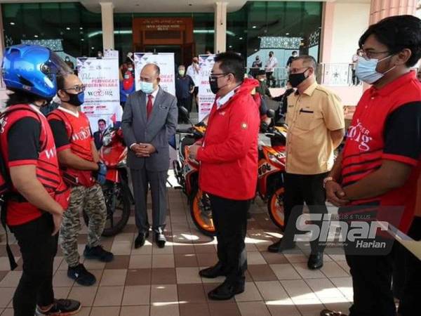 Sulaiman (tiga dari kanan) beramah mesra dengan sebahagian penghantar makanan 'Warong Rider' ketika pelancaran 'Warong Rider' di bawah Program Warongku di Kompleks Seri Negeri, di sini pada Selasa.