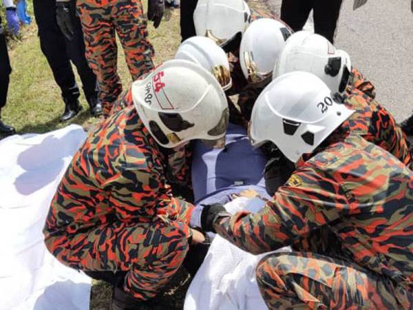 Anggota bomba mengangkat mayat wanita yang tersepit di tempat duduk pemandu selepas terbabas dan melanggar sebatang tiang elektrik di Jalan Tanjung Resang, Kampung Tenglu, Endau, Mersing pada Selasa.