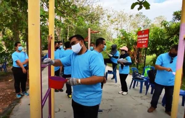 Asrul Nizan (kiri) mengecat persekitaran Pangsapuri Seri Sena sempena gotong royong Program Komunikasi Untuk Perubahan Tingkah Laku (Combi).