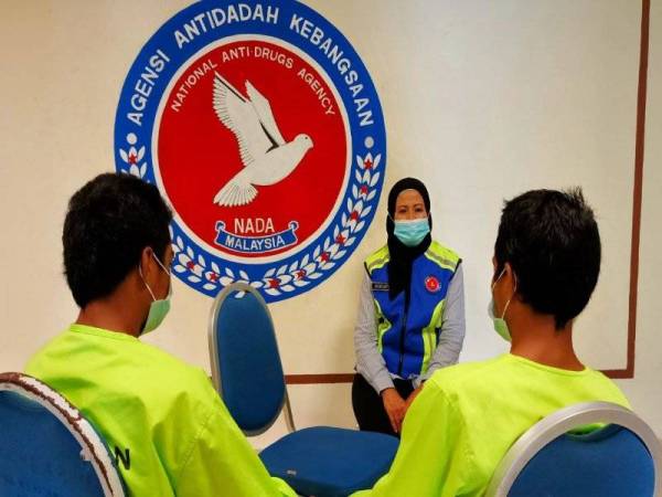 Rohayu memberikan nasihat kepada pemandu lori (kanan) dan adiknya di Ibu Pejabat AADK Pasir Mas di Lubok Jong, Pasir Mas.