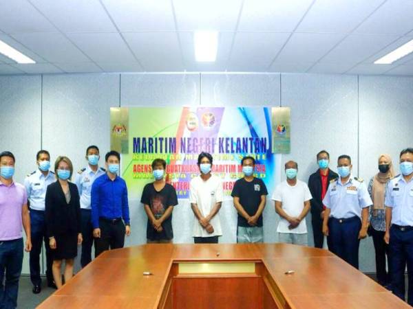 Muhd Nur Syam Asmawie (dua dari kanan) menyerahkan kesemua empat nelayan yang selamat kepada pihak kedutaan Vietnam di pengkalan Maritim Malaysia Tok Bali, Pasir Puteh.