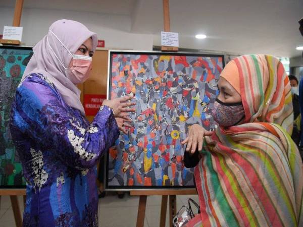 Rina (kiri) berbual bersama penganjur program, Zuraini Anuar (kanan) pada majlis pelancaran Seni Kreatif Bernama sempena Hari Autism Sedunia 2021 di Kuala Lumpur pada Jumaat. Foto Bernama