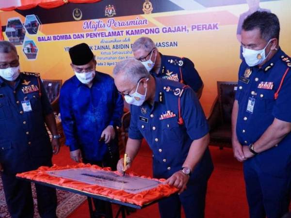 Zainal Abidin menurunkan tanda tangan sebagai gimik perasmian Balai Bomba dan Penyelamat Kampong Gajah, pada Jumaat.