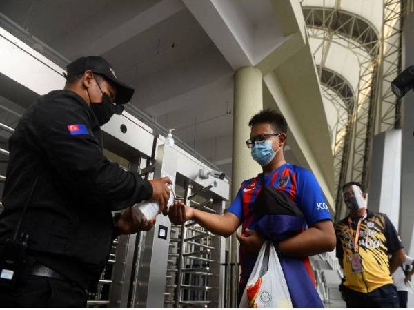 Kelihatan para penyokong Kelab Johor Darul Takzim (JDT) yang pertama tiba untuk mengimbas suhu semasa tinjauan pada perlawanan Liga Super JDT menentang Melaka United FC di Stadium Sultan Ibrahim, Iskandar Puteri hari ini. Foto Bernama