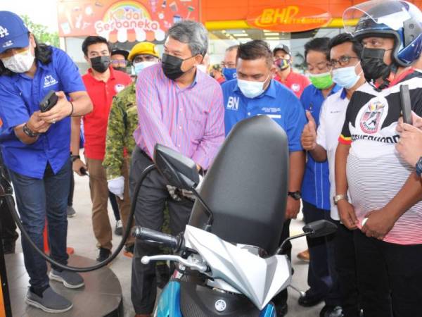 Mohamad mengisi minyak petrol kepada salah seorang penunggang motosikal di Sikamat pada Sabtu.