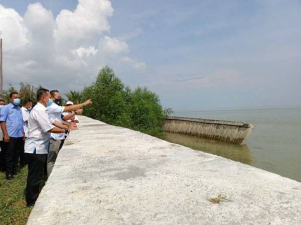 Ahmad Masrizal (dua dari kanan) ketika meninjau keadaan tembok penahan yang runtuh di Kampung Teluk Penikam, Bagan Datuk sempena lawatan kerjanya pada Selasa.