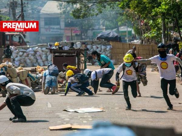 Para penunjuk perasaan antirampasan kuasa melarikan diri ketika anggota-anggota pasukan keselamatan melakukan operasi menyuraikan mereka di Yangon pada Mac lalu. - Foto AFP