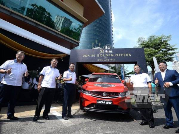 Jalaluddin (tengah) menunjukkan hadiah utama berupa Proton X50 yang bakal dimenangi orang ramai selepas majlis pelancaran kempen ‘UDA 50 Golden Offers’ di Galeri Legasi UDA Kampung Bharu. - Foto Sinar Harian ROSLI TALIB