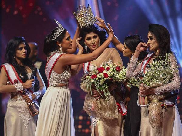 Jurie (dua dari kiri) dengan selamba merampas mahkota de Silva selepas mendakwa wanita itu tidak layak diisytiharkan sebagai pemenang kerana sudah bercerai ketika acara berlangsung di Colombo pada akhir minggu lalu. - Foto AFP