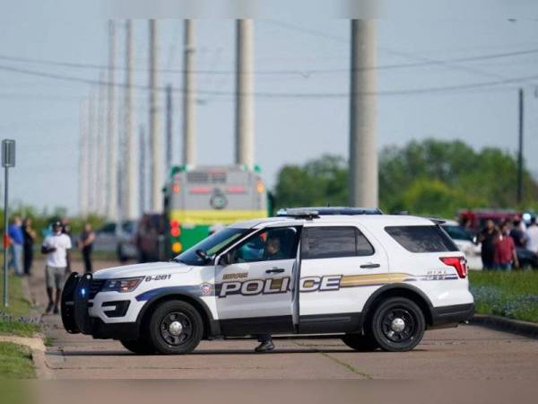 Sebuah kereta polis diletakkan di tempat kejadian selepas seorang individu melepaskan tembakan di gudang syarikat perniagaan Kent Moore Cabinets, Bryan. Texas pada Khamis. - Foto AFP