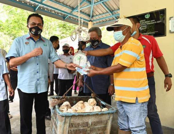 
Mohd Salim (kiri) bersama pekebun kecil melakukan simbolik jualan hasil timbangan skrap yang dikumpul selepas merasmikan Depo Pengumpulan Skrap TSB Kampung Lonek, Jempol pada Khamis.