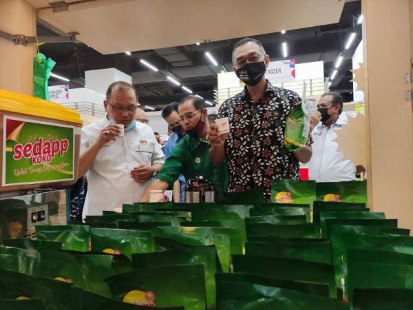 Rosol (kanan) melihat produk usahawan yang dipamerkan dalam Program Jelajah Franchise Bay Peringkat Negeri Terengganu di KTCC Mall pada Sabtu.