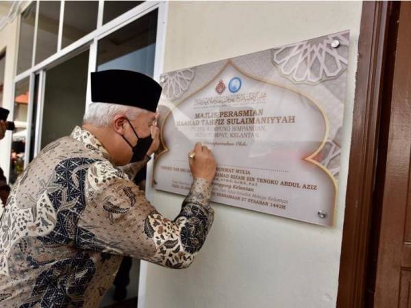 Yang Dipertua Majlis Agama Islam dan Adat Istiadat Melayu Kelantan (MAIK), Tengku Tan Sri Mohamad Rizam Tengku Abdul Aziz menandatangani plak pada Perasmian Maahad Tahfiz Sulaimaniyyah di Kampung Simpangan, Tumpat pada Sabtu.