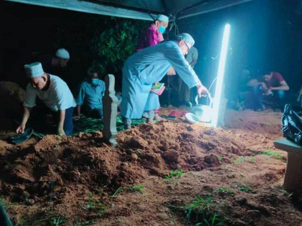 Ahli keluarga ibu arwah Surya menyiram air mawar di atas kubur sejurus selesai pengebumian di Tanah Perkuburan Islam Kampung Beladau Selat, Kuala Terengganu - Foto: ihsan Keluarga