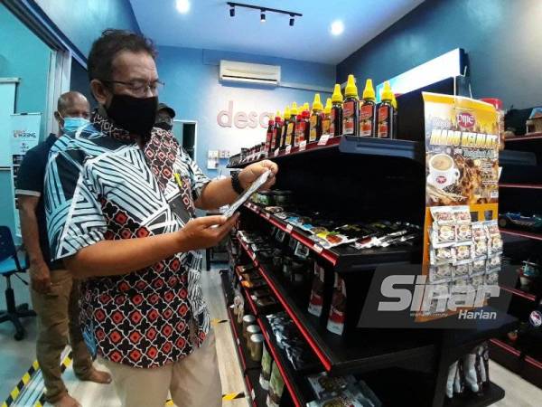 Abdul Latiff melihat produk usahawan tempatan yang dijual di DesaMall PKD Air Merah, Mersing pada Sabtu.