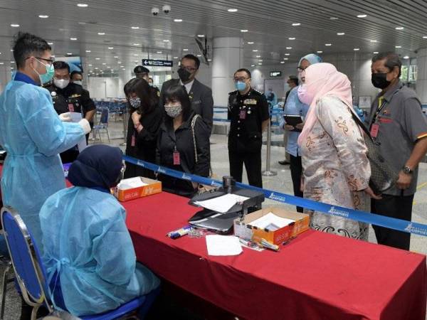 Mahmood (kanan) mengadakan lawatan ke empat agensi penguatkuasaan di Lapangan Terbang Antarabangsa Kuala Lumpur (KLIA) pada Isnin.