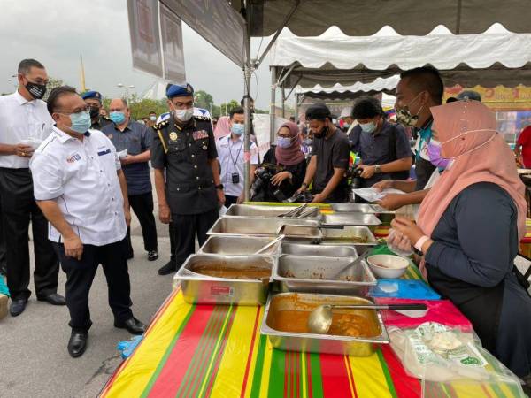 Alexander (baju putih) meninjau kepatuhan SOP peniaga di bazar Ramadan Presint 3, Putrajaya.