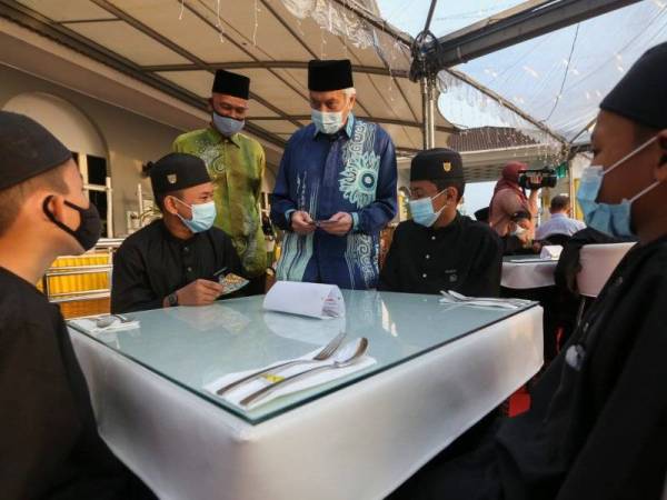 Abdul Aziz (tengah berbaju biru) menyampaikan duit raya kepada anak yatim yang diraikan pada majlis berbuka puasa. 