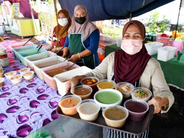 Peniaga Bubur Anak Lebah, Sarpah Salwa Abd Rahim, 57, (kanan) menunjukkan pelbagai aneka jenis bubur yang dijual termasuk bubur Anak Lebah di rumahnya di Taman Perpaduan. - Foto Bernama