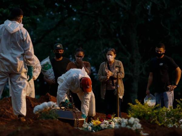 Pekerja di tanah perkuburan Vila Formosa di Sao Paulo, Brazil mengenakan sut perlindungan khas ketika mengebumikan korban Covid-19. - Foto AFP