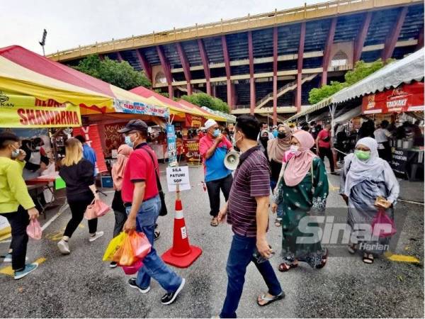 Penganjur bazar Ramadan Paroi Jaya, Aslam Nawabdin menggunakan pembesar suara mengingatkan pengunjung dan peniaga mematuhi SOP.