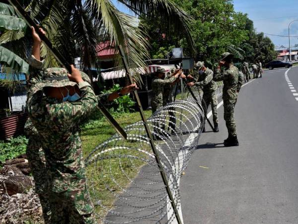 Anggota Batalion ke-26 Rejimen Askar Melayu Diraja (RAMD) memulakan tugas memasang kawat berduri di Kampung Muhibbaraya selepas kawasan itu dikenakan PKPD ketika tinjauan pada 11 April lalu. - Foto Bernama