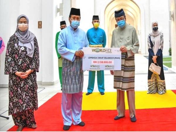 Sultan Sharafuddin (kanan) menerima zakat daripada Worldwide Holdings Berhad pada majlis diadakan di Masjid Tengku Ampuan Jemaah Bukit Jelutong, Shah Alam pada Isnin.