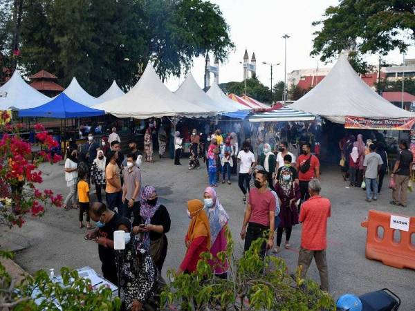 Pengunjung mematuhi SOP dengan memakai pelitup muka dan memeriksa suhu badan sebelum dibenarkan masuk ke bazar Ramadan ketika tinjauan di Dataran Shahbandar sebelum ini. Foto Bernama