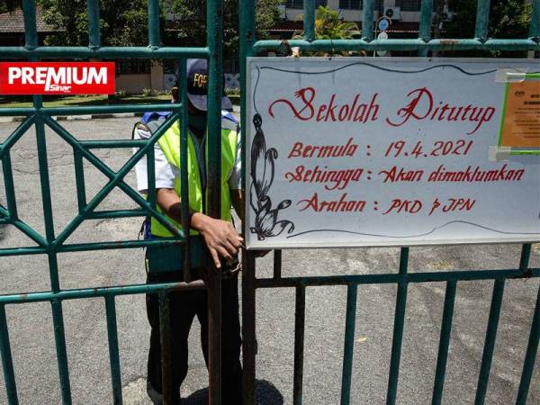 Pengawal Keselamatan Asis Samsudin, 41, menutup pagar sekolah berikutan penutupan Sekolah Kebangsaan (SK) Bandar Baru Sri Damansara 2, pada Selasa. - Foto Bernama