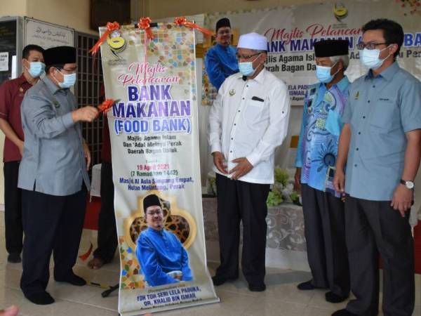 Khalid (kiri) menyempurnakan pelancaran pertama Bank Makanan di Masjid Al-Aula Simpang Empat, Hutan Melintang pada 19 April lalu.