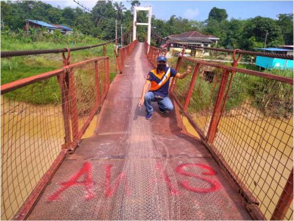 Hassan menunjukkan keadaan struktur Jambatan Gantung Sungai Dingin di Temerloh yang meresahkan penduduk kampung.