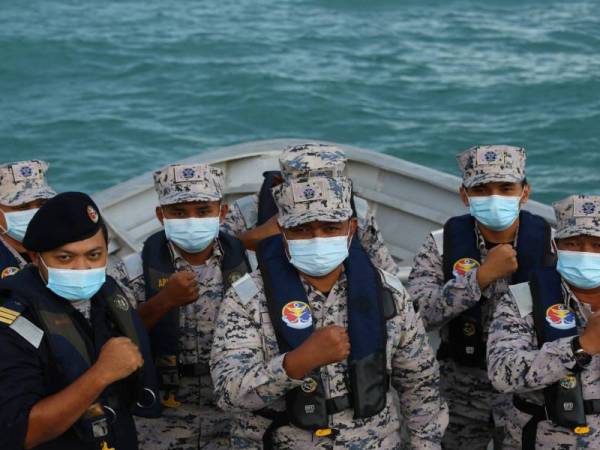 Nurul Hizam (dua dari kanan) bergambar bersama anggotanya di atas kapal, KM Perwira, milik APMM yang disediakan untuk pihak media menimba pengalaman dan berbuka puasa pada Program Berbuka Bersama Media dan Maritim di Perairan Johor Timur, Kota Tinggi pada Rabu. - Foto Bernama