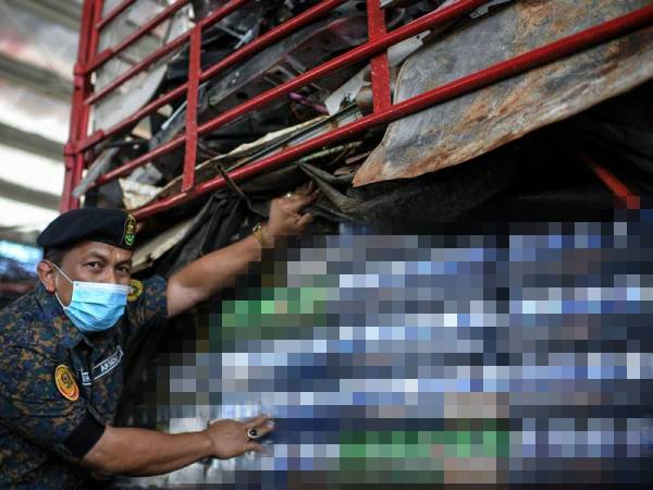 Mohd Khairi menunjukkan barangan rampasan sebanyak 1,000 karton minuman keras bernilai RM1.2 juta termasuk cukai yang dibawa masuk dari Langkawi di Jeti Laut, Kuala Kedah pada Rabu. - Foto Bernama