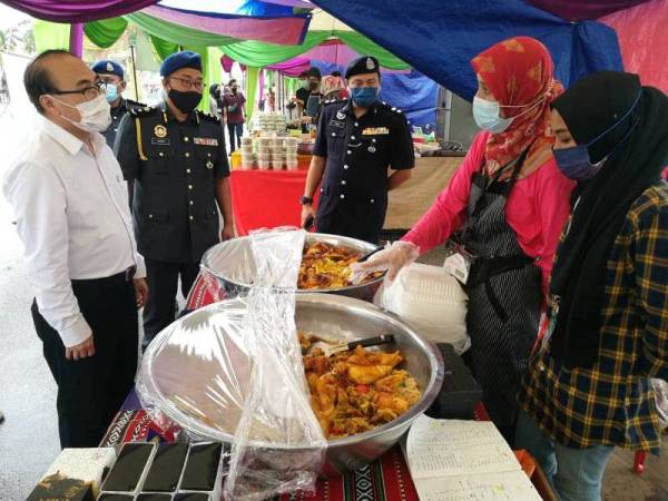 Fat Full (kiri) dan Mohd Hairul Anuar (dua dari kiri) dalam lawatan dan pemeriksaan SHMMP Hari Raya Puasa di bazar Ramadan di Angsana Mall Johor Bahru, Johor Bahru pada Khamis.