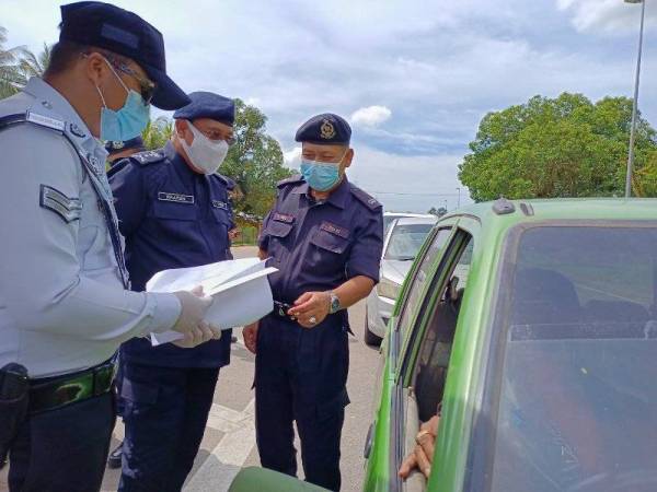 Shafien (tengah) bersama Azmir (kanan) turun padang meninjau penugasan di SJR Bukit Yong, Pasir Puteh pada Jumaat.